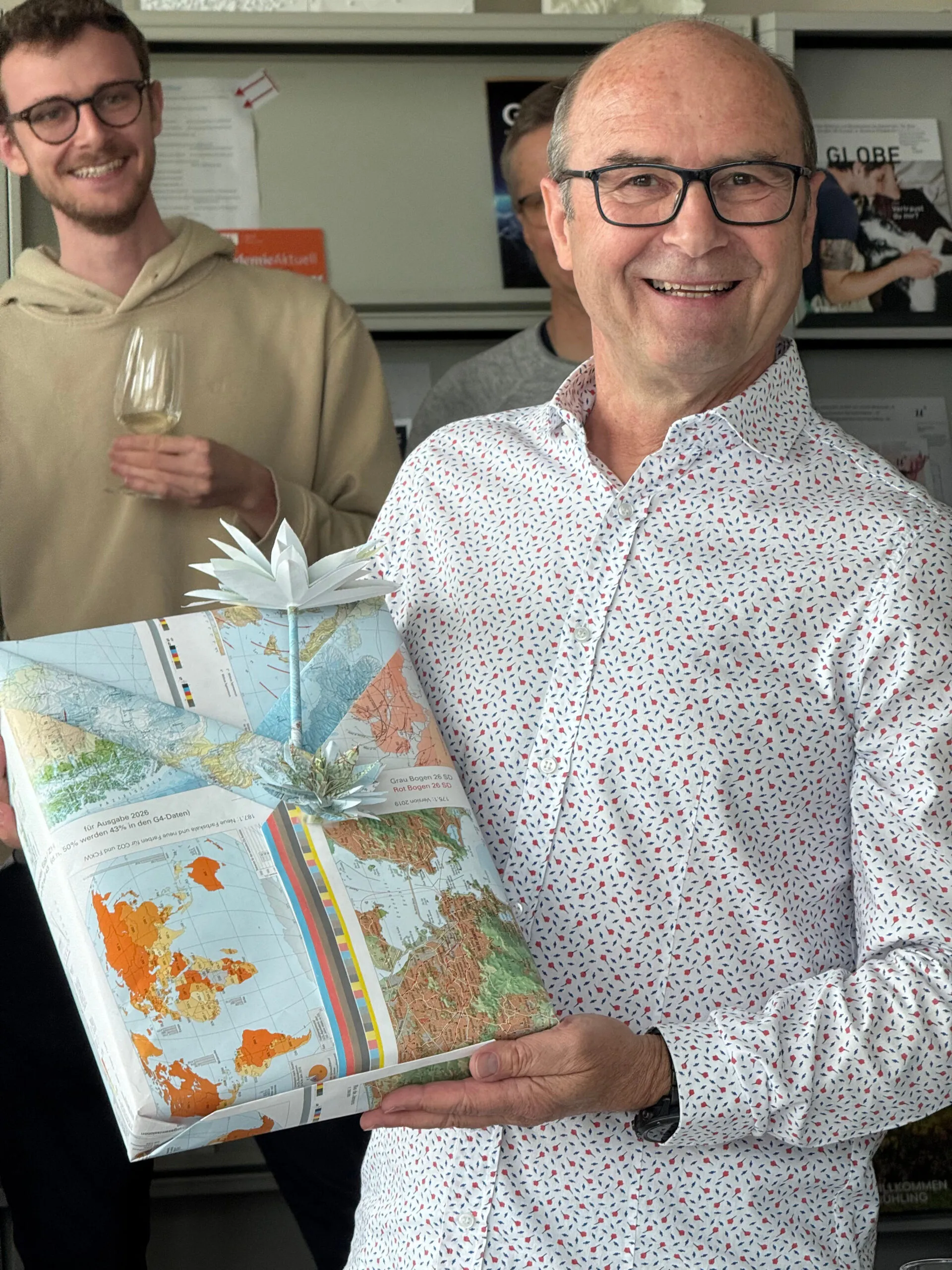 Uomo che riceve un regalo impacchettato in una carta geografica.